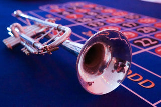 A trumpet rested on a roulette table.