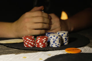 Stacks of red and blue poker chips with hands.