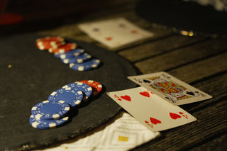 Poker chips and playing cards on a dark table.